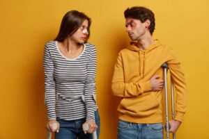 Dissatisfied woman and man have accident, unlucky day, have talk with eah other, stand on crutches,